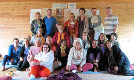 Archived photo of Muz Murray guiding an early mantra workshop circle with close student participation.